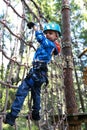 Child overcoming mesh obstacle in forest adventure park Royalty Free Stock Photo