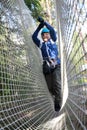 Child overcoming mesh obstacle in rope park