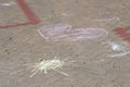 child painted the sun and heart on the pavement with colored chalk