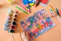 Child painting abstract with flowers and smiles, hello summer, Children development . The concept of a happy childhood and happy