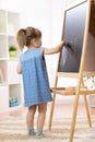 Child painting at easel in school.