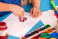 Child painting heart in art school class. Mother day holiday.