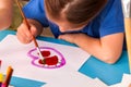 Child painting heart in art school class. Mother day holiday.