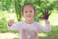 Child painting, little girl having fun to paint on paper in the green garden Royalty Free Stock Photo