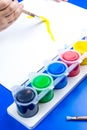 Child is painting a picture with tempera paints Royalty Free Stock Photo