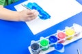Child is painting a picture with tempera paints Royalty Free Stock Photo