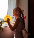 Child painting pumpkin on window preparing to celebrate Halloween. Little girl decorates her room autumn holiday at home Royalty Free Stock Photo