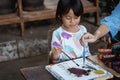 Child painting on white fabric