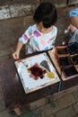 Child painting on white fabric