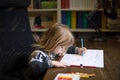 Child painting white sheet on wooden table Royalty Free Stock Photo