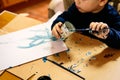 Child paints with a brush on a blank sheet