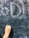 A child paints by chalk on a school board Royalty Free Stock Photo