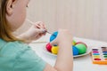 The child paints blue easter egg Royalty Free Stock Photo