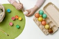 child paints eggs with colorful paints and puts them in a basket, easter content Royalty Free Stock Photo