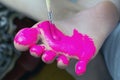 A child paints his feet with red paint to make prints of children`s feet