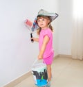 The child paints the wall with a roller