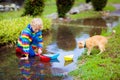 Child with paper boat in puddle. Kids by rain Royalty Free Stock Photo