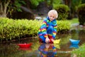 Child with paper boat in puddle. Kids by rain Royalty Free Stock Photo