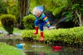 Child with paper boat in puddle. Kids by rain Royalty Free Stock Photo