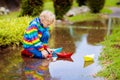 Child with paper boat in puddle. Kids by rain Royalty Free Stock Photo