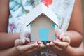 Child and parent holding paper house in hands together Royalty Free Stock Photo