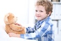 Child patient afrer health exam playing as a doctor with stethoscope and teddy bear