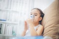 Child patient inhalation therapy by the mask of inhaler with soft stream smoke from bronchodilator. Royalty Free Stock Photo