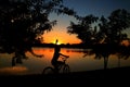 Child pedaling bicycle at the dusk of the lagoon