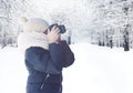 Child photographer with camera taking picture forest landscape in snowy winter