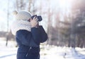 Child photographer takes picture on the digital camera outdoors