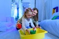 Child with physical disability in sensory stimulating room, snoezelen. Child living with cerebral palsy interacting with therapist