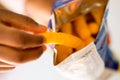 Child picking Cheese puffs snack from pack Royalty Free Stock Photo