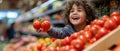 Child Picks Tomatoes From Grocery Display With Excitement In A Bustling Store Royalty Free Stock Photo