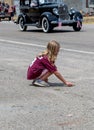 Child picks up candy during a parade Royalty Free Stock Photo