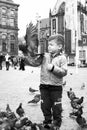 child with pigeon in Dam Square in Amsterdam in the Netherlands