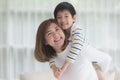 Child on a piggy back ride with his mother at home