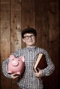 Child, piggy bank or book in thinking for education, studio background or savings for finance lesson in youth. Boy