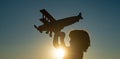 Child pilot aviator with airplane dreams of traveling. Child dreams. Child on the background of sunset sky. Royalty Free Stock Photo