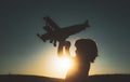 Child pilot aviator with airplane dreams of traveling. Child dreams. Child on the background of sunset sky. Royalty Free Stock Photo