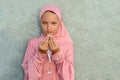 A child in a pink hijab with a beads in his hands with copy space. People religious lifestyle concept Royalty Free Stock Photo