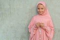 A child in a pink hijab with a beads in his hands with copy space. People religious lifestyle concept Royalty Free Stock Photo