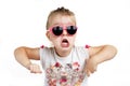 Child in pink sunglasses making funny face. positive girl shouts on a white background Royalty Free Stock Photo