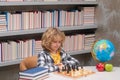 Child play chess in classroom at school. Chess for intelligent kid. Child genius, smart pupil playing logic board game. Royalty Free Stock Photo