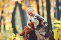 Child play with dog in autumn forest. Child with husky and teddy bear on fresh air outdoor Royalty Free Stock Photo