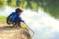 Child play fishing near lake. Royalty Free Stock Photo