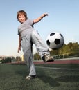 Child play soccer football player. Boy kick on ball on green grass Royalty Free Stock Photo