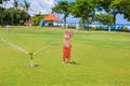 Child play, swim and splash under water sprinkler spray Royalty Free Stock Photo