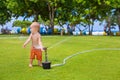 Child play, swim and splash under water sprinkler spray Royalty Free Stock Photo