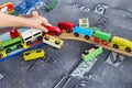 Child play with wooden train, build toy railroad at home or kindergarten. Toddler kid play with wooden train Royalty Free Stock Photo