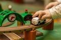 Child play with wooden train, build toy railroad at home or kindergarten. Toddler kid play with wooden train Royalty Free Stock Photo